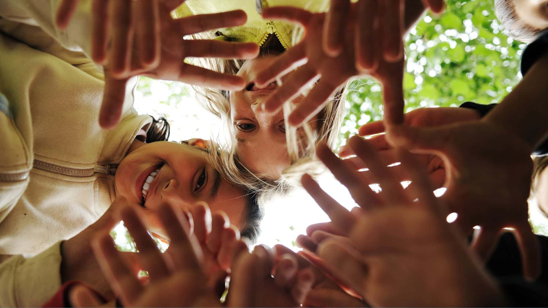 Group of children in a circle looking down