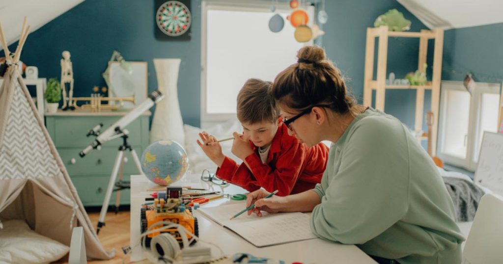 Young female tutoring young boy