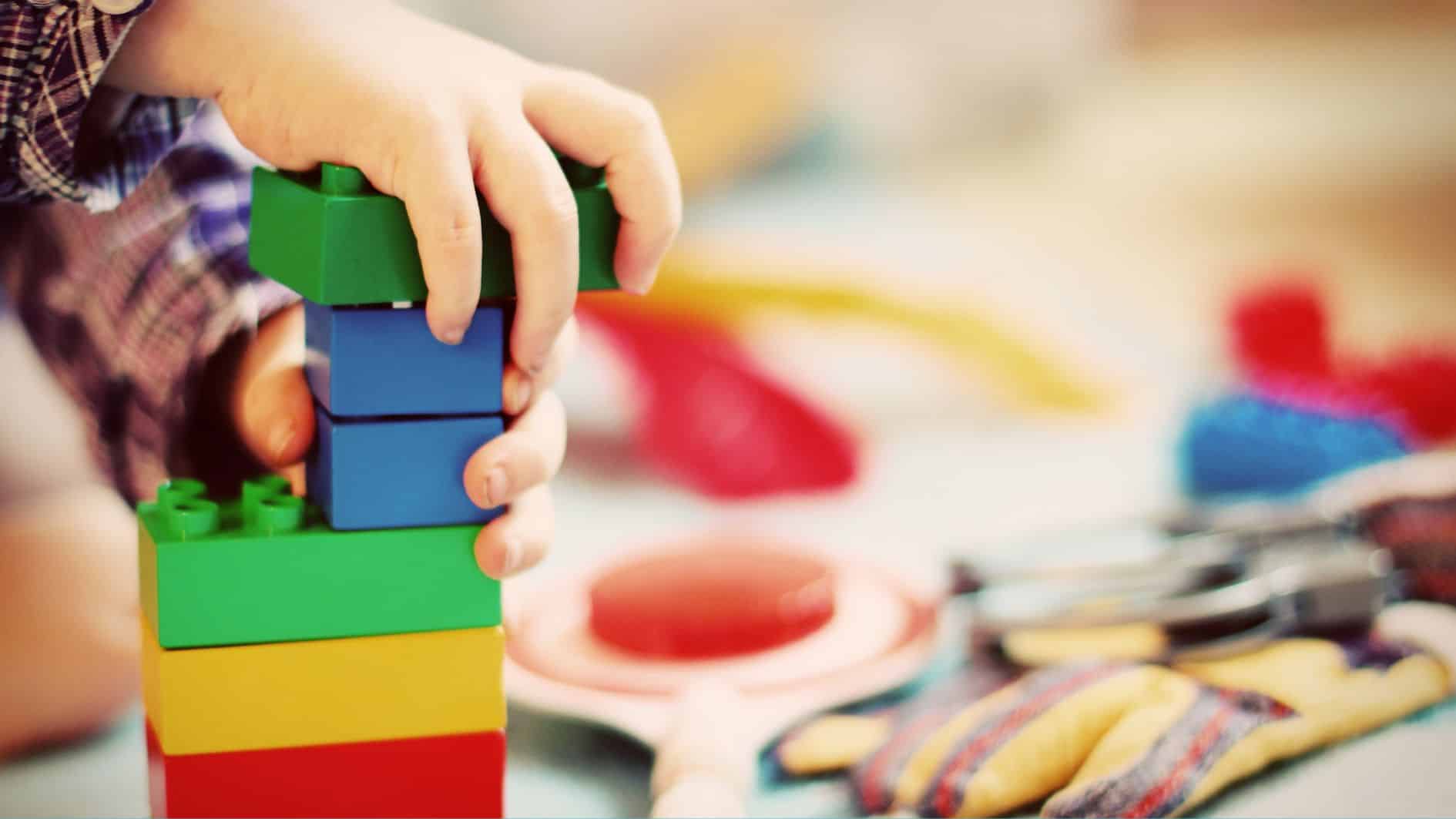 Hands holding colorful building blocks